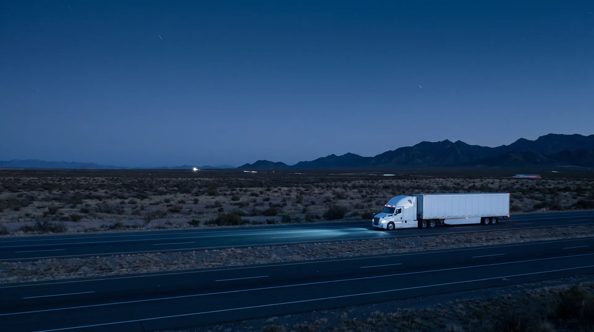 Tractocamión en una carretera del norte de México, de noche, con las luces encendidas